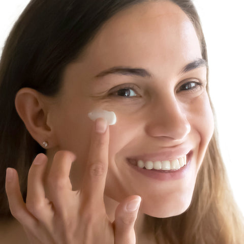 Woman applying soothing sensitive skin cream.