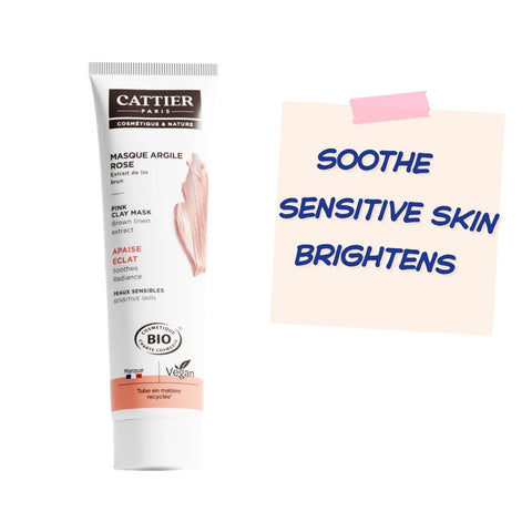 A tube of Cattier Paris Masque Argile Rose clay mask stands next to a peach-colored sticky note with blue text that reads 'SOothe SENSITIVE SKIN BRIGHTENS' on a plain white background.