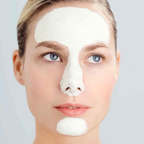 Woman with a white face mask representing combination skin collection