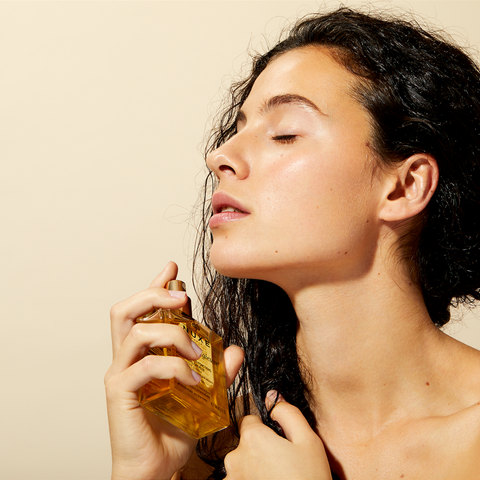 women applying Nuxe multipurpose oil om hair